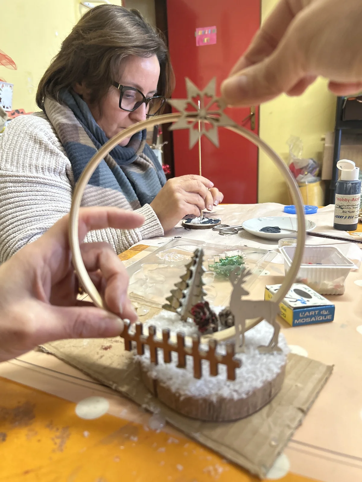 Dettaglio delle mani durante la realizzazione di una decorazione