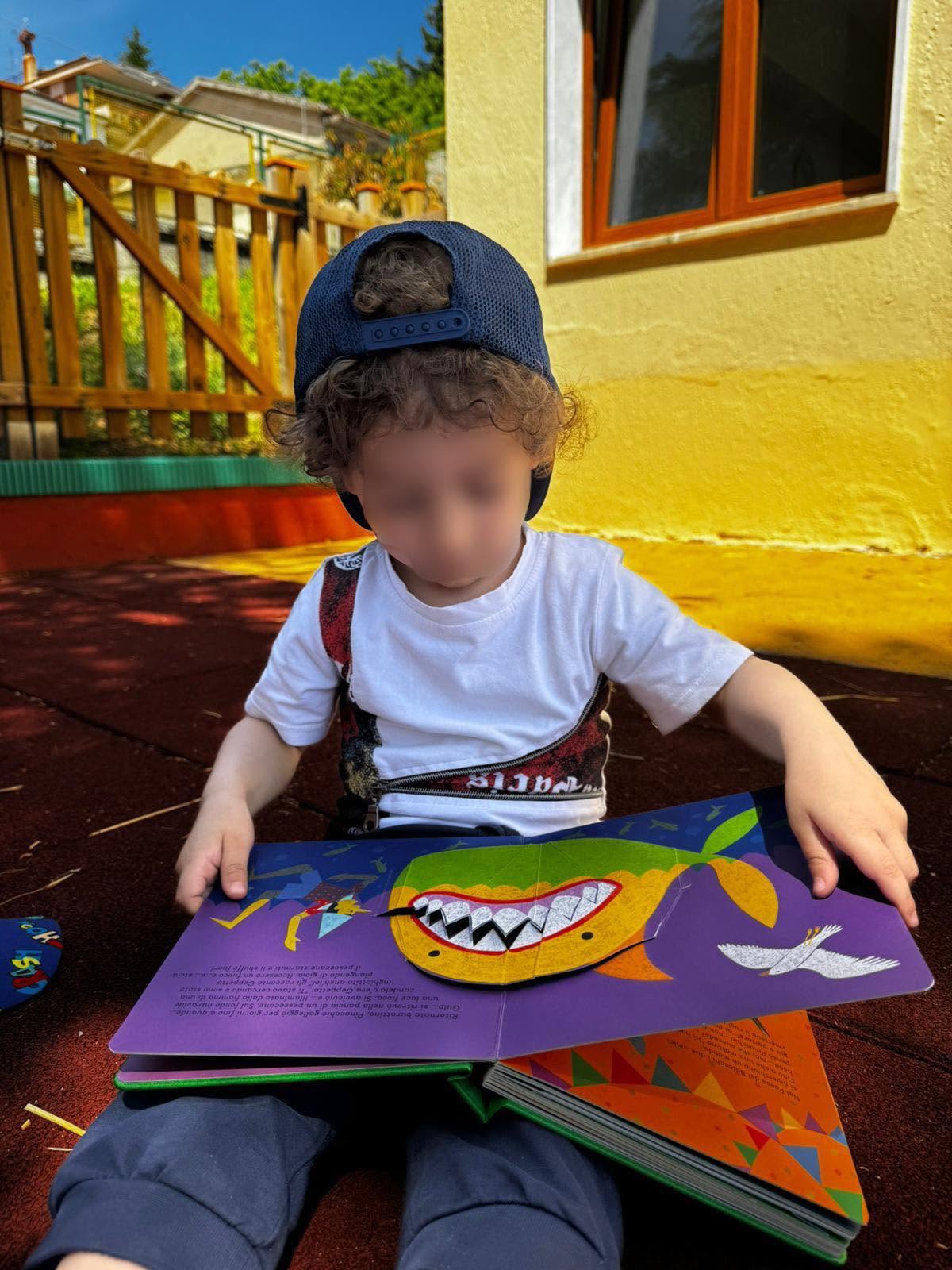 Bambino impegnato in una lettura animata all'aperto